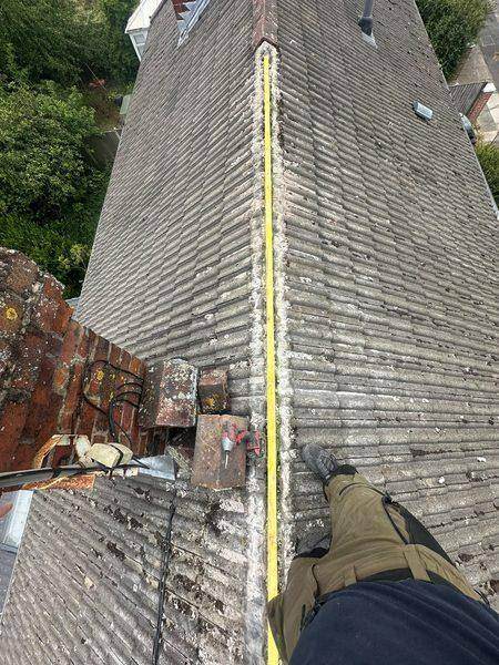 Old clay ridge tiles stacked on the slope beside the tools