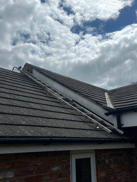 Working up the gable off a roof ladder hooked over the slope