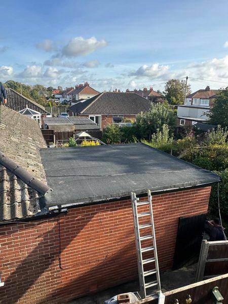 The finished roof on the brick outbuilding, ladder against the wall