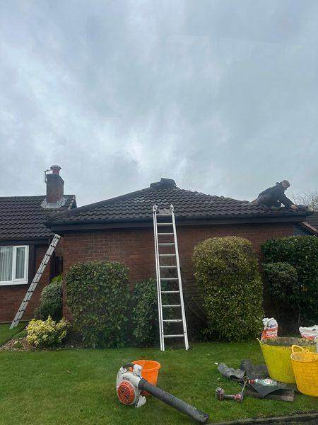 Working along the ridge with the tiles off, tools and buckets below