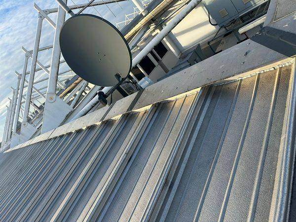 The coping run above the profiled metal sheeting, satellite dish alongside